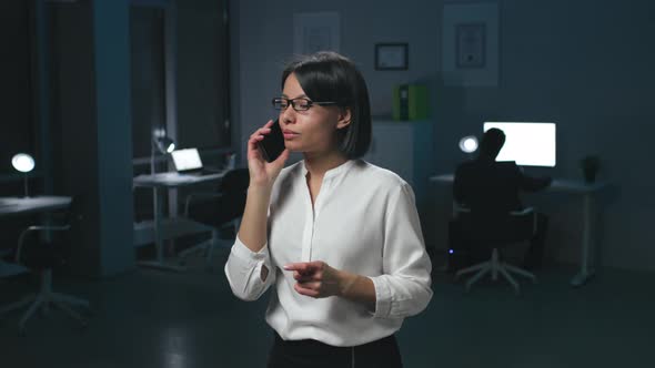 Smiling AfricanAmerican Businesswoman Talk on Smartphone Late in Office