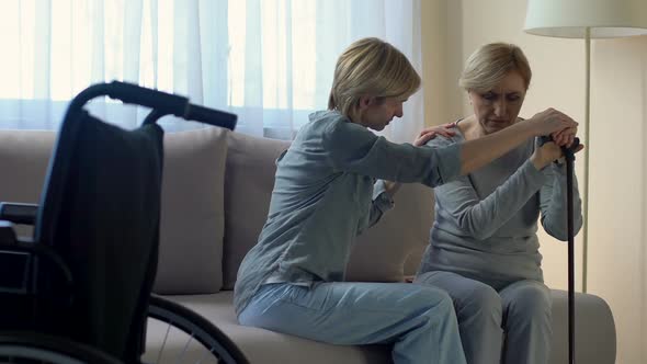 Female Psychologist Supporting Lonely Disabled Senior Woman at Nursing Home