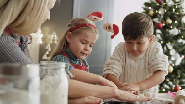 Video of children and mother cutting out gingerbread cookies. Shot with RED helium camera in 8K.