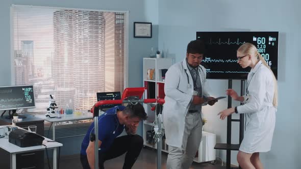 Doctors Providing First Aid To the Athlete Who Has Suddenly Feel Bad and Fallen Down During Stress alt