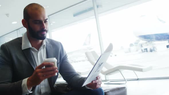 Businessman having coffee while reading a document