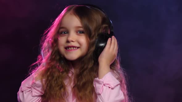 Little Girl Dancing on Smoky Background in Headphones, Slow Motion