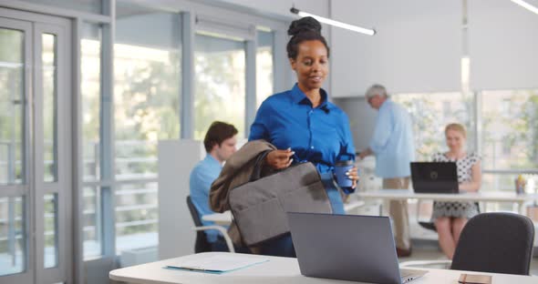 Afroamerican Woman Entering Office and Greeting Colleagues