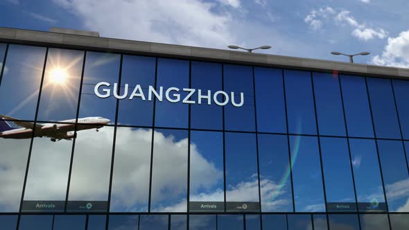 Airplane landing at Guangzhou China airport mirrored in terminal