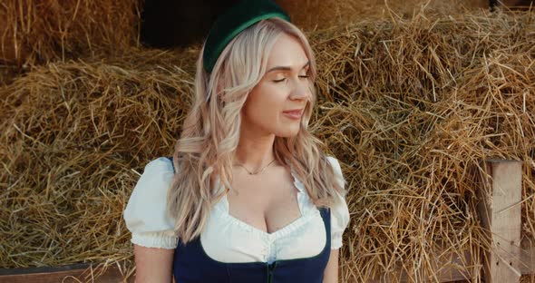 Cute Slavic Blonde Crosses Hands and Looks Into Camera with Passion at Hayloft