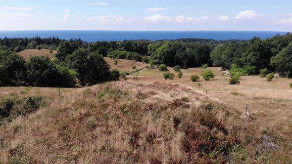 Aerial view of the coastline of Sejerøbugten with hills, fields and ocean.