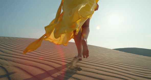 Close-up Woman in Yellow Stylish Fashion Dress Walking Barefoot By Rippled Dune