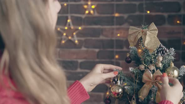 Woman Adjusts Bows on Christmas Tree and Little Boy Talks