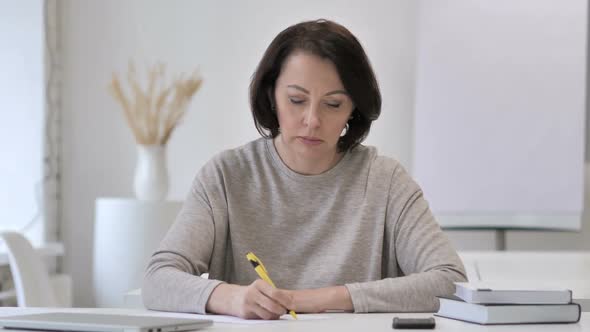 Old Senior Woman Writing on Documents Paperwork
