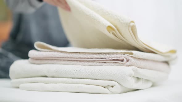 Female Hand Taking Clean Fresh Towel From Pile