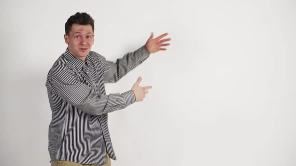 A Young Man of Caucasian Appearance in a Shirt on a White Background Shows the Emotion of Admiration