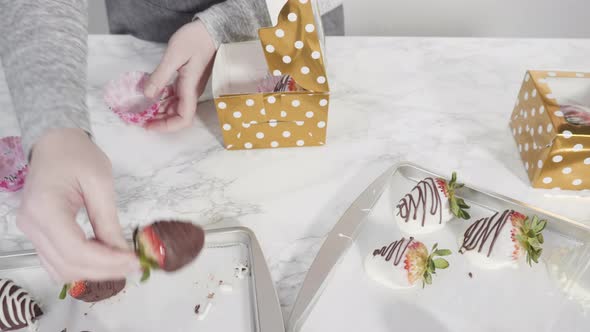 Step by step. Packaging chocolate dipped strawberries into a paper box for a gift.