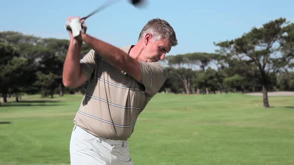 Mature man playing golf on golf course