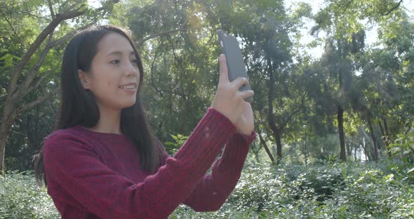 Woman taking selfie on cellphone in the park 