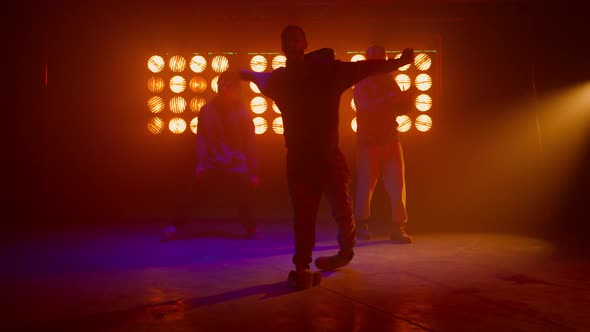 Dancing Team Silhouette Performing Modern Movements in Nightclub Backlight