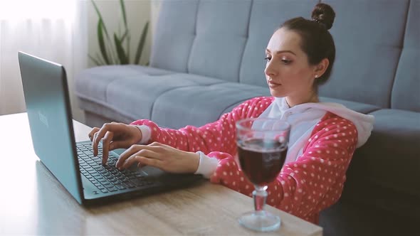 Professional Freelancer Types on Laptop and Drinks Red Wine