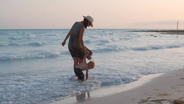 Cute Baby Boy Sitting in Water at Seaside