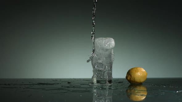 Carbonated liquid pouring into glass filled with ice 