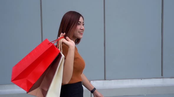slow-motion of happy woman walking with shopping bags