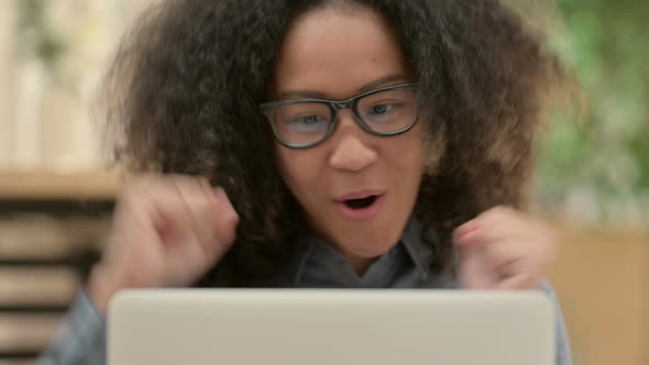 Close Up of African Woman Celebrating Success on Laptop