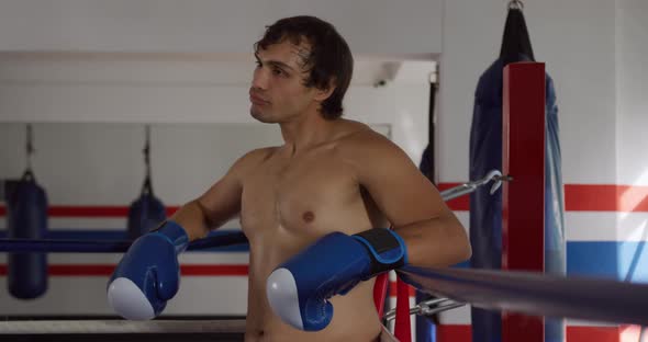 Caucasian man resting in boxing ring