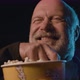 Senior man watching a funny comedy movie at the cinema, he is laughing and eating popcorn - VideoHive Item for Sale