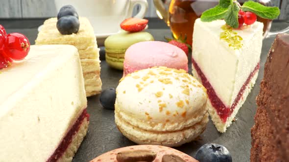 Various Sweets and Green Tea Teapot. Cakes, Berries, Coffee Beans, Mint Leaves. Slider Shot, UHD