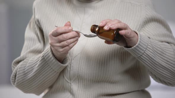 Old Lady Pouring Cough Syrup in Spoon With Trembling Hands, Health Treatment