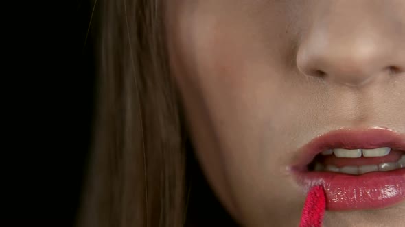 Hands of the Artist Make-up Which Draws the Girl's Lips Close-up. Bone Paints Her Lips with Red