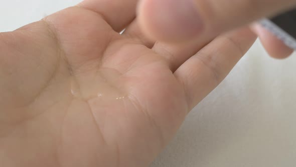 Closeup on the Palm of a Colorless Cream Dripping Lotion to Moisturize the Skin