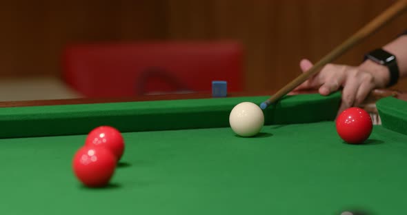 Striking snooker ball on table