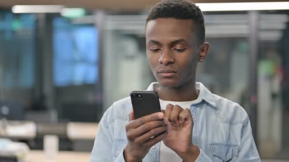 Portrait of African Man Loss on Smartphone