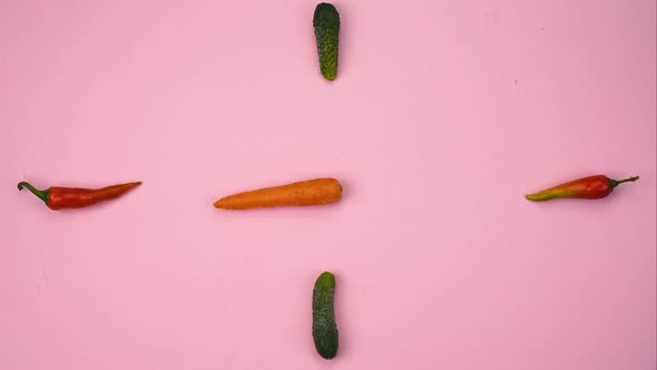 Clock From Vegetables Moving Arrows From Carrots on a Pink Concrete Background Stop Motion 