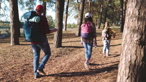 Happy Family Hiking Through a Forest