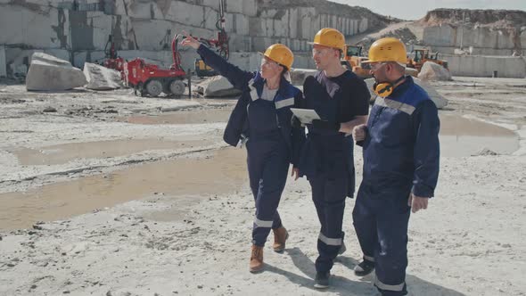 Workers with Tablet Inspecting Granite Quarry