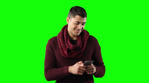 Caucasian man using a smartphone on green background