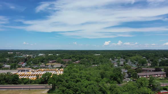 A high angle shot over a field where the camera dolly in and tilts down. It's a beautiful day with b