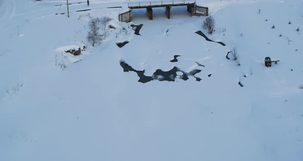 Aerial View of a Village in the Snow in Winter on the Bank of a Frozen River