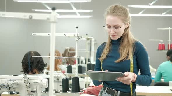 Portrait of fashion designer woman standing in a sewing shop.