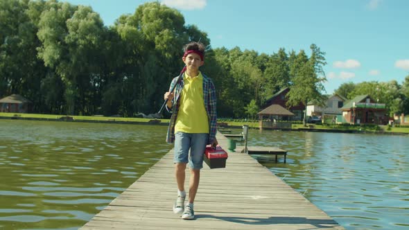 Happy Young Fisherman with Fishing Rod and Tackle Box Going for Angling on Pond