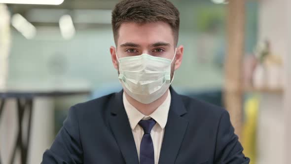 Young Businessman with Face Mask Looking at the Camera