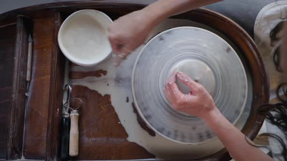 Skilled Female Potter is Working with Pottery Wheel in Workshop Top View