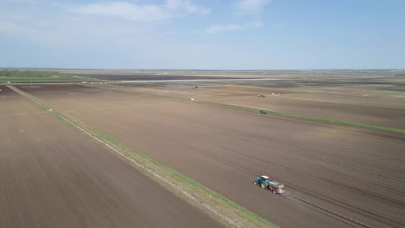 Tractor on Agricultural Lands Is Cultivated with Fertilizers