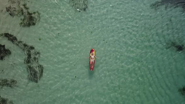 Woman Relaxing in the Sea on a Surfboard