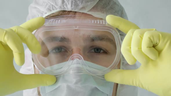 Closeup Face of Man Doctor in Mask and Protective Suit in Coronavirus Pandemic.