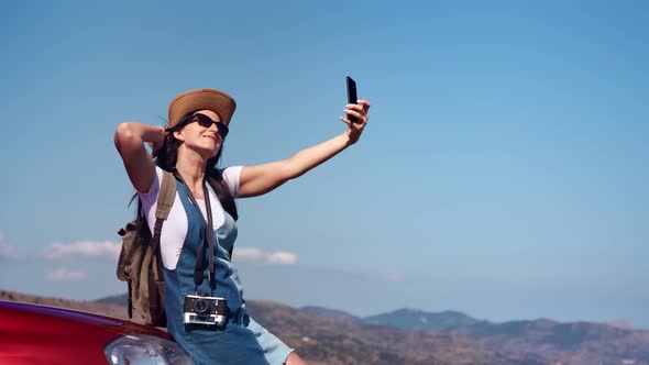 Pleasant Happy Travel Woman Enjoying Journey at Mountain Landscape Taking Selfie Using Smartphone