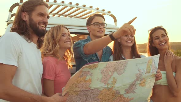 Summer Travel. Friends Using Map Near Car In Nature. Happy Smiling People Traveling