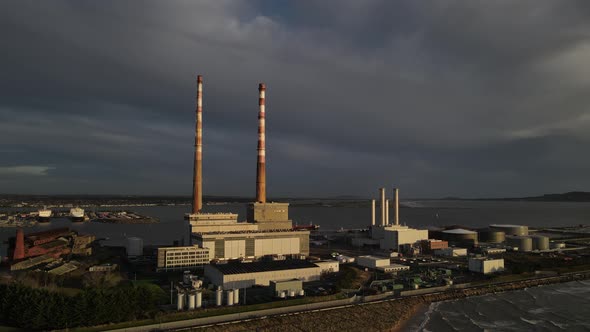 The Poolbeg Towers In Dublin Ireland With View Of Dublin Port On A Dramatic Sunset - aerial drone (a