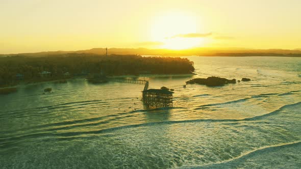 Big Waves Are Coming and Beautiful Sunset Landscape at the Wooden Bridge on Cloud 9 Beach, Siargao