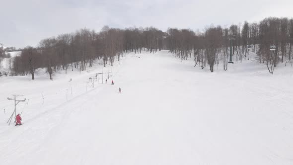 Aerial view of the ski resort with snowy mountain slopes and winter trees. 